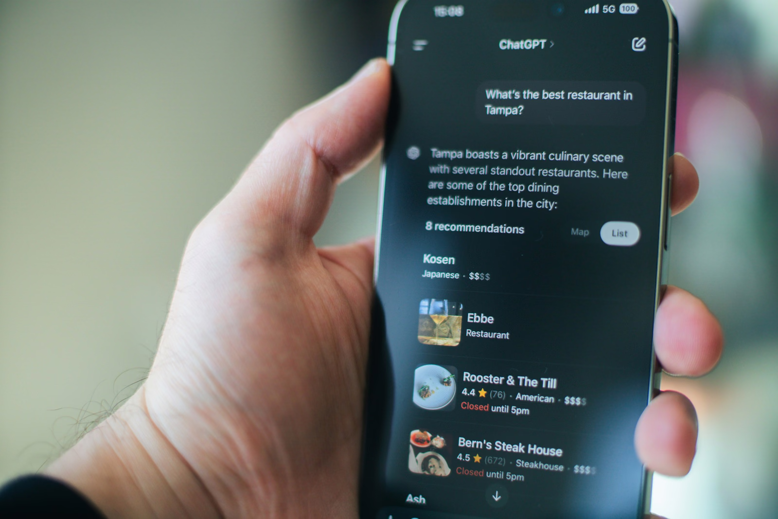 Hand holding a phone showing ChatGPT listing local restaurant recommendations with star ratings